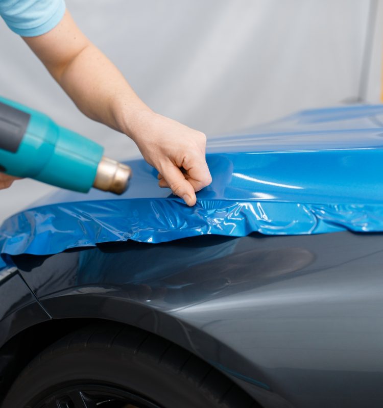 Car wrapping, mechanic with drier installs film