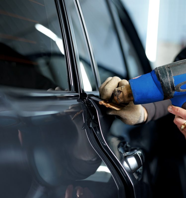 Close up of male car service worker applying nano coating on a car