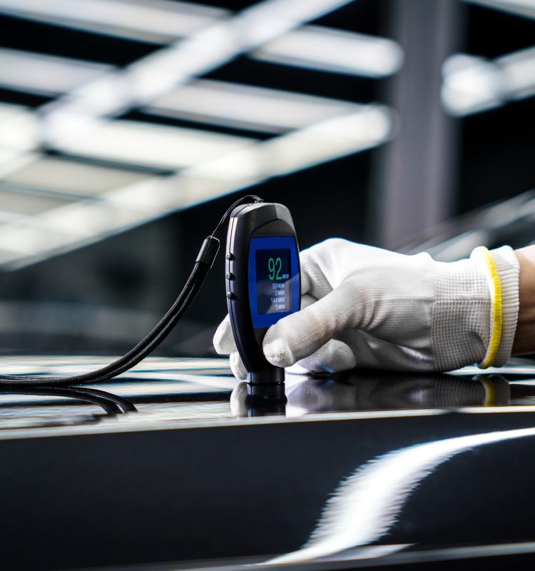 Measuring the thickness of a car paint coating with a thickness gauge